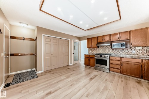 Spacious kitchen area featuring light wood flooring, wood cabinetry, and stainless steel appliances - 4224 30 Street, Edmonton, AB - Indoor Photo Showing Kitchen