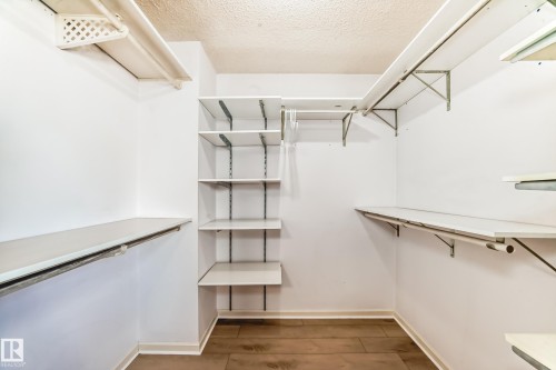The property features a spacious closet with white shelving units and hanging rods, offering extensive storage solutions - 4224 30 Street, Edmonton, AB - Indoor With Storage
