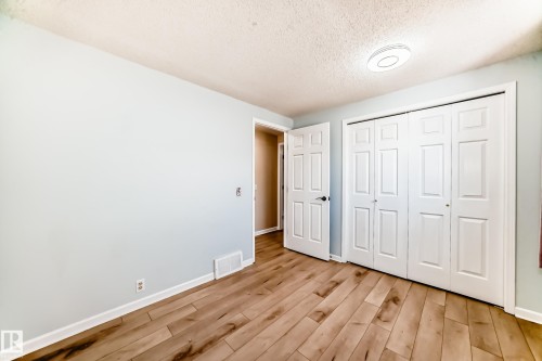 This room features wood plank flooring, a closet with bi-fold doors, and a ceiling light fixture - 4224 30 Street, Edmonton, AB - Indoor Photo Showing Other Room