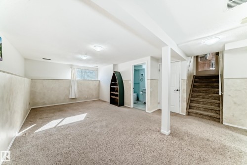 Spacious lower level featuring carpeted flooring, a window providing natural light, and a staircase - 4224 30 Street, Edmonton, AB - Indoor Photo Showing Other Room