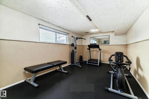 Dedicated exercise room with durable black flooring and a window providing natural light - 4224 30 Street, Edmonton, AB - Indoor Photo Showing Gym Room