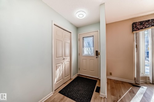 Entryway featuring light hardwood flooring, a white front door with a decorative glass insert, and a closet with bifold doors - 4224 30 Street, Edmonton, AB - Indoor Photo Showing Other Room