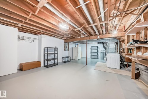 The property features a spacious unfinished basement with exposed wooden joists and concrete flooring, offering ample storage space and a laundry area with a visible washing machine - 4224 30 Street, Edmonton, AB - Indoor Photo Showing Basement