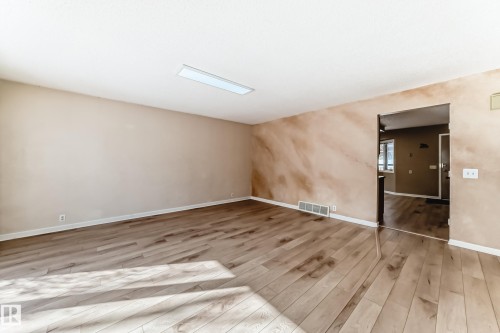 The property features wood flooring, a rectangular ceiling light fixture, and light-toned walls - 4224 30 Street, Edmonton, AB - Indoor Photo Showing Other Room