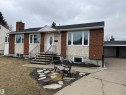Split-level residence featuring a brick and stucco facade, an attached carport, and a dark shingle roof - 11948 132 Street, Edmonton, AB  - Outdoor 