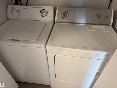 White top-loading washing machine and front-loading dryer - 11948 132 Street, Edmonton, AB - Indoor Photo Showing Laundry Room