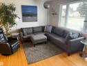 Hardwood flooring throughout featuring a large window with horizontal blinds, built-in floating shelves, and white wall finishes - 11948 132 Street, Edmonton, AB  - Indoor Photo Showing Living Room 