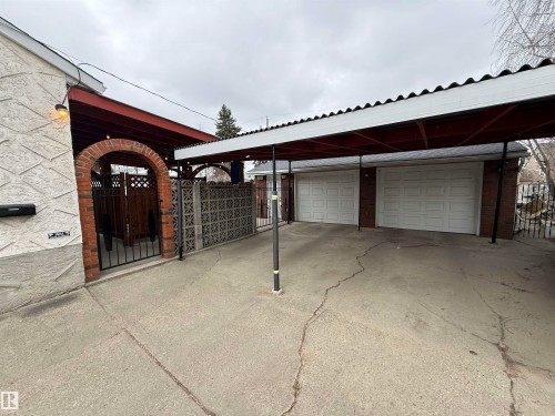 Concrete driveway leading to a two-car garage with white panel doors - 11948 132 Street, Edmonton, AB - Outdoor