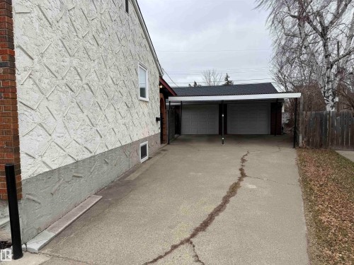 Two-car carport with a corrugated roof, offering covered parking and direct access to the property - 11948 132 Street, Edmonton, AB - Outdoor