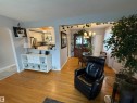 Hardwood-finish flooring throughout, featuring a kitchen pass-through window with a built-in shelf - 11948 132 Street, Edmonton, AB  - Indoor 