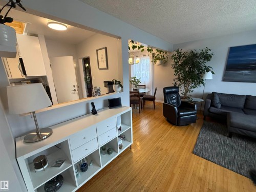 Hardwood-finish flooring extending through living areas - 11948 132 Street, Edmonton, AB - Indoor Photo Showing Living Room
