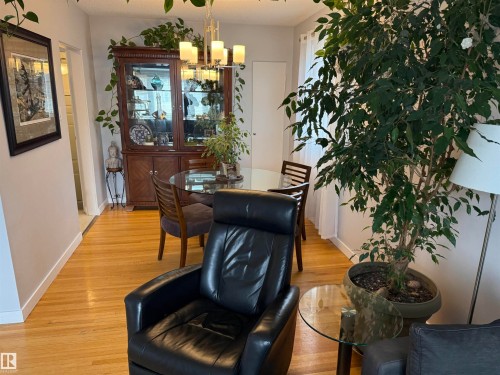 Hardwood-finish flooring throughout, complemented by a contemporary chandelier - 11948 132 Street, Edmonton, AB - Indoor Photo Showing Dining Room