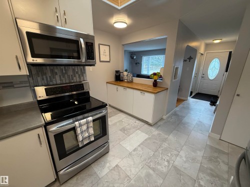 Modern kitchen featuring stainless steel appliances, including an over-the-range microwave and electric range - 11948 132 Street, Edmonton, AB - Indoor Photo Showing Kitchen