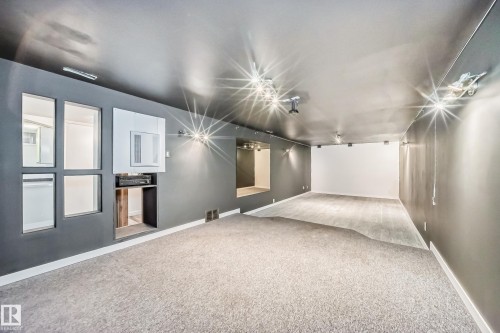 Spacious room featuring modern track lighting and a built-in media console - 5204 112 Avenue, Edmonton, AB - Indoor Photo Showing Other Room