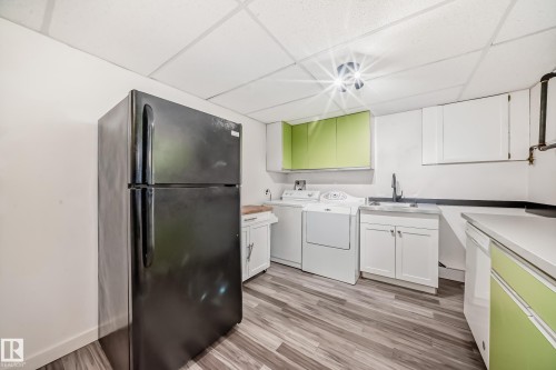 Utility room featuring wood-finish flooring, white walls, and a drop ceiling - 5204 112 Avenue, Edmonton, AB - Indoor Photo Showing Laundry Room