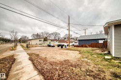 Expansive cleared lot with sidewalk frontage, surrounded by existing residential structures - 