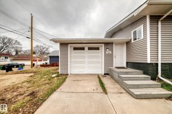 Siding exterior with a white garage door featuring transom windows - 