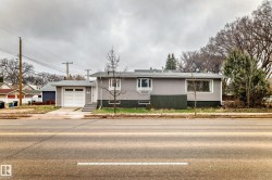Grey siding exterior featuring white trim and a single-car garage with a white panel door - 