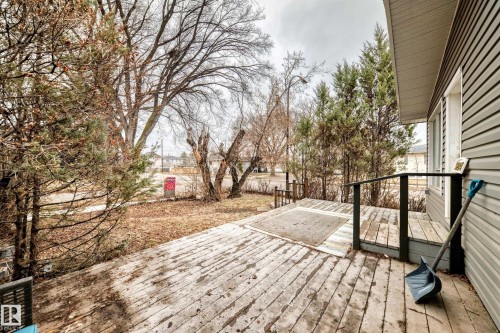 Exterior wood deck with dark railing and gray siding - 5204 112 Avenue, Edmonton, AB - Outdoor