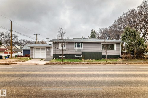 Grey siding exterior featuring white trim and a single-car garage with a white panel door - 5204 112 Avenue Nw, Edmonton, AB - Outdoor