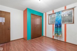 Interior room featuring wood-finish flooring and white walls with accent stripes - 
