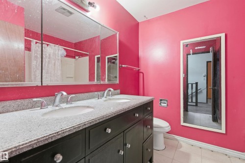 Double vanity with a light-colored countertop and dual undermount sinks - 11211 77 Avenue, Edmonton, AB - Indoor Photo Showing Bathroom