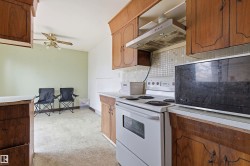 Kitchen featuring wood-finish cabinetry, white countertops, and a tile backsplash - 