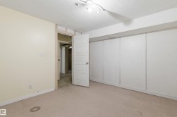 Carpeted room featuring light beige wall paint and a textured ceiling - 