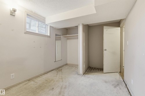Interior room featuring a window, wall-mounted sconce lighting, and a neutral color palette - 11211 77 Avenue, Edmonton, AB - Indoor Photo Showing Other Room