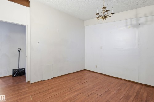 Room with wood-finish flooring, white painted walls, and a textured ceiling - 11211 77 Avenue, Edmonton, AB - Indoor Photo Showing Other Room