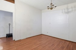 Room with wood-finish flooring, white painted walls, and a textured ceiling - 