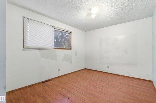 Room featuring wood-finish flooring, white walls, and a window with horizontal blinds - 11211 77 Avenue, Edmonton, AB - Indoor Photo Showing Other Room