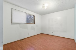 Room featuring wood-finish flooring, white walls, and a window with horizontal blinds - 