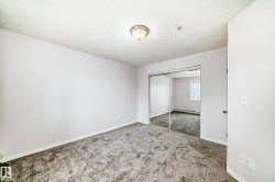 Bedroom featuring gray carpeting, white walls, and a ceiling-mounted light fixture - 