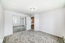 Spacious room with plush gray carpeting and white baseboards - 
