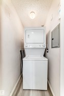 Dedicated laundry area featuring a stacked washer and dryer unit - 