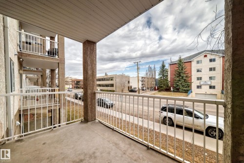 Private balcony with concrete flooring and white metal railing - 218 10535 122 Street, Edmonton, AB - Outdoor With Exterior