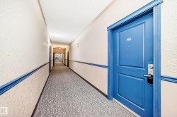 Long interior hallway with textured wallpaper and crown molding - 