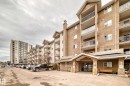 Multi-story residential building featuring stucco facade, individual balconies with white railings, and a prominent covered entryway - 218 10535 122 Street, Edmonton, AB  - Outdoor With Facade 