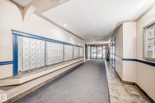 Interior hallway with individual mailboxes and a carpeted walkway - 218 10535 122 Street, Edmonton, AB - Indoor Photo Showing Other Room