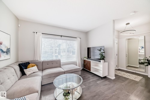 Spacious living area featuring wood-finish flooring, a large window with horizontal blinds, and recessed lighting - 3278 Cherry Crescent, Edmonton, AB - Indoor Photo Showing Living Room
