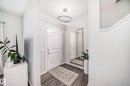 Entryway featuring wood-finish flooring, a contemporary ceiling light fixture, a full-length wall mirror, white paneled doors, and light gray wall paint - 3278 Cherry Crescent, Edmonton, AB  - Indoor Photo Showing Other Room 