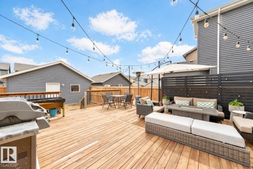 Expansive wood deck featuring a split-level design, wood privacy fencing, and string lighting - 3278 Cherry Crescent, Edmonton, AB - Outdoor With Deck Patio Veranda With Exterior