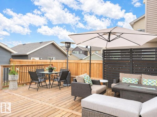 Expansive wood deck with a full-height wood fence, black privacy screen, and an attached umbrella - 3278 Cherry Crescent, Edmonton, AB - Outdoor With Deck Patio Veranda With Exterior
