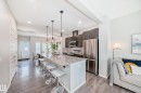 Open-concept kitchen featuring an oversized island with a granite countertop, dark wood-finish cabinetry, and stainless steel appliances - 3278 Cherry Crescent, Edmonton, AB  - Indoor Photo Showing Kitchen With Upgraded Kitchen 