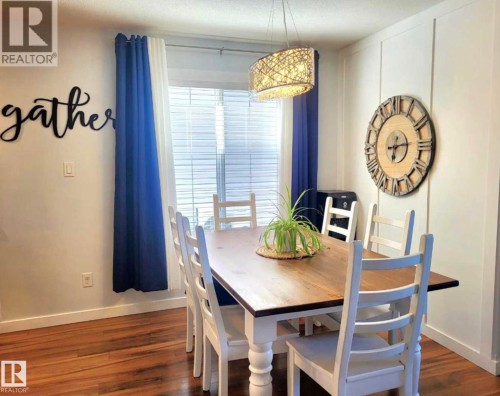 Dining area featuring wood-finish flooring, white baseboards, and a window with blinds - 144 Kirpatrick Way, Leduc, AB - Indoor Photo Showing Dining Room