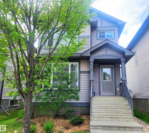 Two-story home with a covered front porch and concrete steps - 144 Kirpatrick Way, Leduc, AB - Outdoor