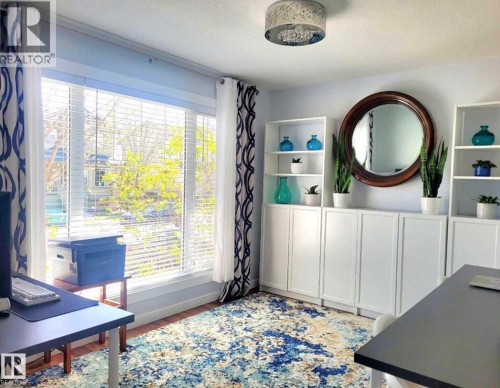 Bright room featuring a large window with blinds, light blue wall paint, and wood-finish flooring - 144 Kirpatrick Way, Leduc, AB - Indoor Photo Showing Other Room