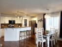 Open-concept kitchen and dining area featuring rich wood-finish flooring - 144 Kirpatrick Way, Leduc, AB  - Indoor 