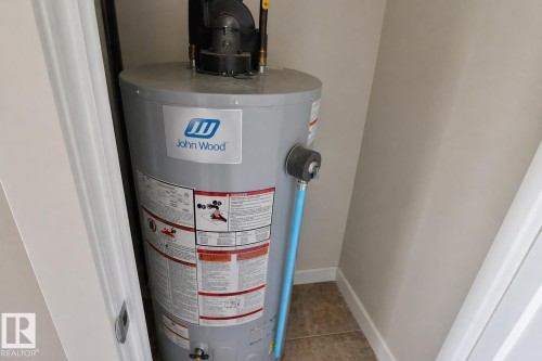 John Wood water heater appliance - 81 446 Allard Blvd, Edmonton, AB - Indoor Photo Showing Basement